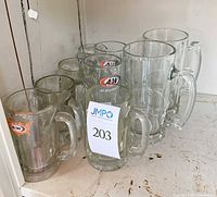 Group of assorted A&W branded root beer mugs and clear glass beer steins on a shelf