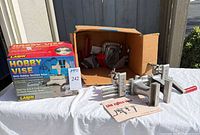 Lot overview showing Zyliss vise components, Larin hobby vise box, steel C-clamp and accessory parts