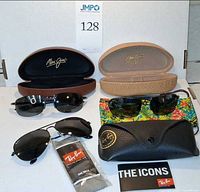 Overview of three sunglasses pairs with respective cases and accessories