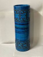 Front view of tall blue ceramic cylindrical vase showing overall shape and decorative band