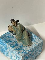 Front view of ceramic Shiwan Mudman scholar figurine on rock base
