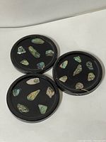 Top view, all three coasters showing abalone fragments on black bases