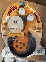 Front view of sealed Joie Eggsentials pan, spatula and booklet in package