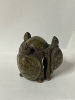 front view showing three turtle heads, shells, missing leg area