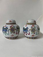 Front view of both lidded ginger jars showing full painted designs