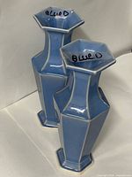 Front view of two blue faceted ceramic vases