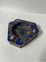 Top view showing floral cloisonné decoration, pentagonal shape, three cigarette rests