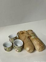 Three cups and two wrapped bundles showing pattern and quantity