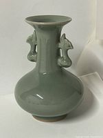 Front view of green ceramic vase showing handles and shape