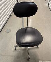 Front view of black leather rolling chair