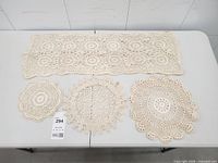 Overview of all four crochet lace pieces laid flat on table