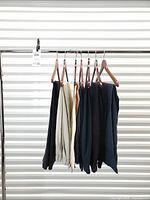 Seven pairs of trousers on hangers, full view of lot
