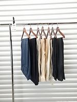 Full lot of seven trousers on hangers