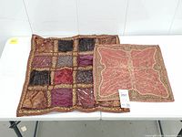 Both cushion covers laid flat on table showing full designs