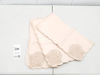 Stack of peach napkins showing scalloped edges and lace corners