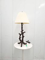Full view of table lamp with cream shade on stand