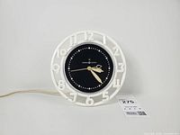 Front view of General Electric Telechron LK-11 wall clock showing bezel, dial, hands and power cord