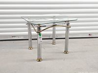 angled view showing glass top, legs, brass feet