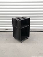 Full front-side view showing ribbed design, shelves and castors