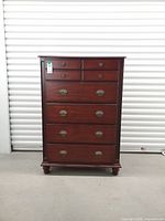 Front view of mahogany chest showing all drawers and hardware