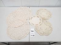 Full lot of six doilies arranged on table