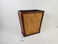 Full view front-side of rectangular wood-framed rattan wastebasket