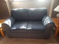 Front view of blue loveseat showing cushions and arms