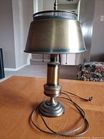 Front view of brass table lamp showing base, column, shade, pull chains and cord