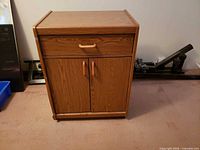 Front view showing drawer, double doors, casters