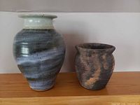 Both pottery vases side by side on shelf