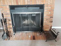 Overall view of fireplace screen, tool set and log basket