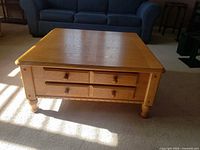 Front view showing drawers, turned legs and wood finish