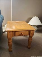 Full view front left of wood side table next to sofa