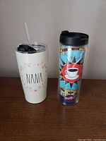 Front view of both tumblers showing designs and lids