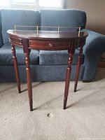 Full view of demilune side table showing front, legs, drawer