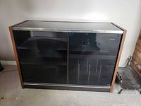 Front view of Toshiba cabinet showing glass sliding doors and interior shelves