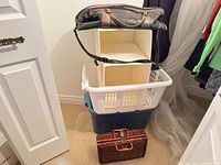 Stack showing all items: leather duffel, two fabric cubes, white laundry basket, blue tote, wicker basket