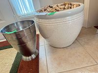 ceramic planter filled with corks beside metal urn planter