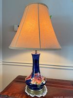 Full view of Moorcroft lamp lit on table