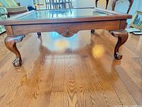 Full view of coffee table showing cabriole legs, carved shell apron, glass top