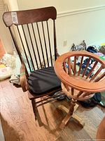 Rocking chair with cushion beside plant stand