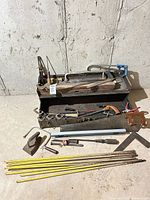Lot overview showing toolbox, saws, clamps, plane, level, rebar and other tools