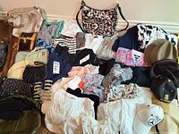 Full layout of clothing, handbags, hats and accessories on floor