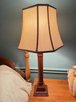 Full view of lamp on table showing base, column, and hexagonal shade