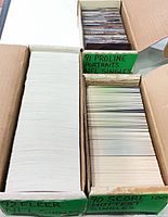 Three boxes of trading cards showing sorting and quantity