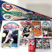 Lot overview showing pennant, publications, can, cards and VHS