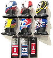 Front view of six mini goalie masks and three boxed mini sticks