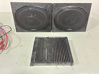 Front view of Alpine 3542 amplifier flanked by the two speaker enclosures