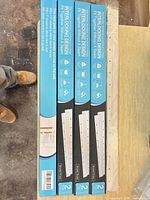 Four retail boxes of 30-inch aluminum French cleat hanger kits side by side