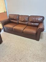 Front view of three-seat brown leather sofa